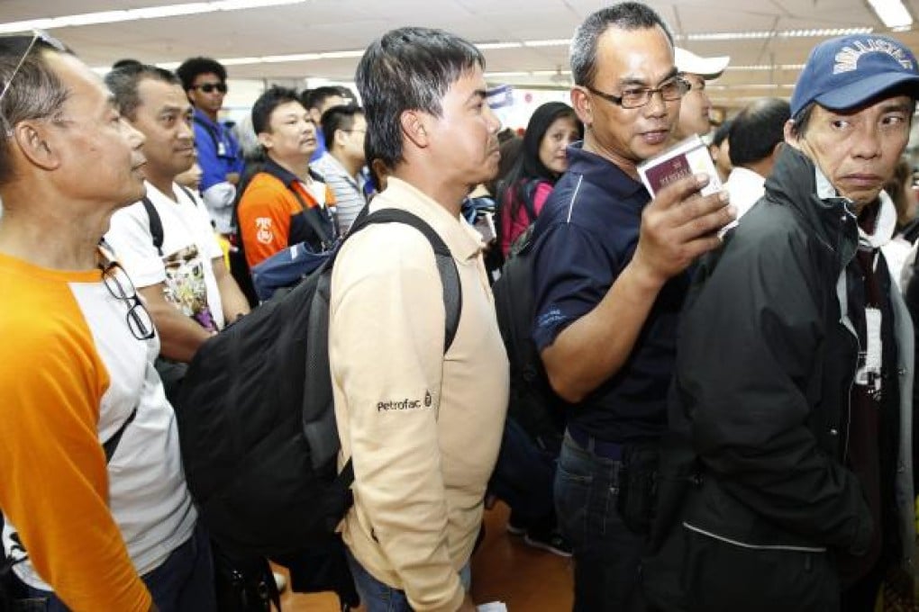 Filipino workers arrive in Manila from Algeria on Sunday. Photo: EPA