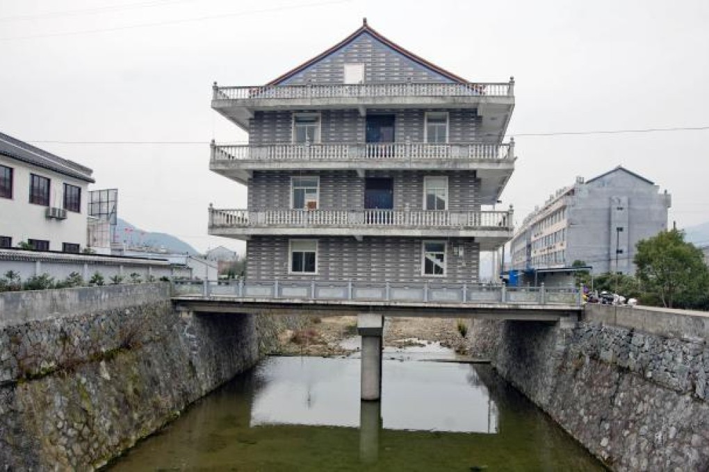 A photo taken on Jan. 22, shows a three-story building on top of a stilt over a spillway in Wenling, Zhejiang province. Photo: ImageChina