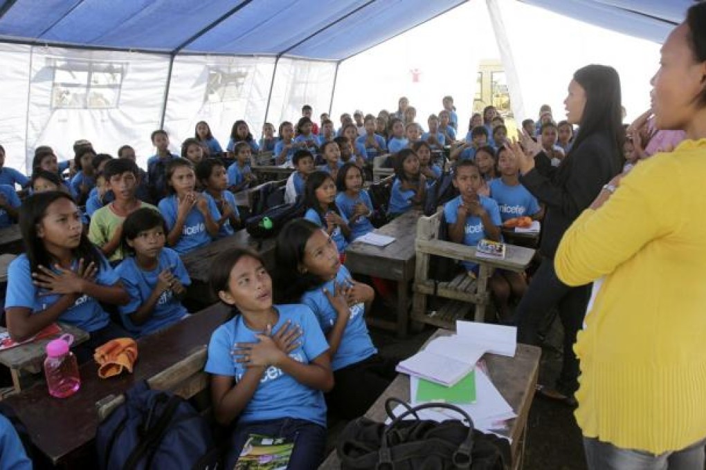 A class is held in a tent at an evacuation centre. Photo: Reuters
