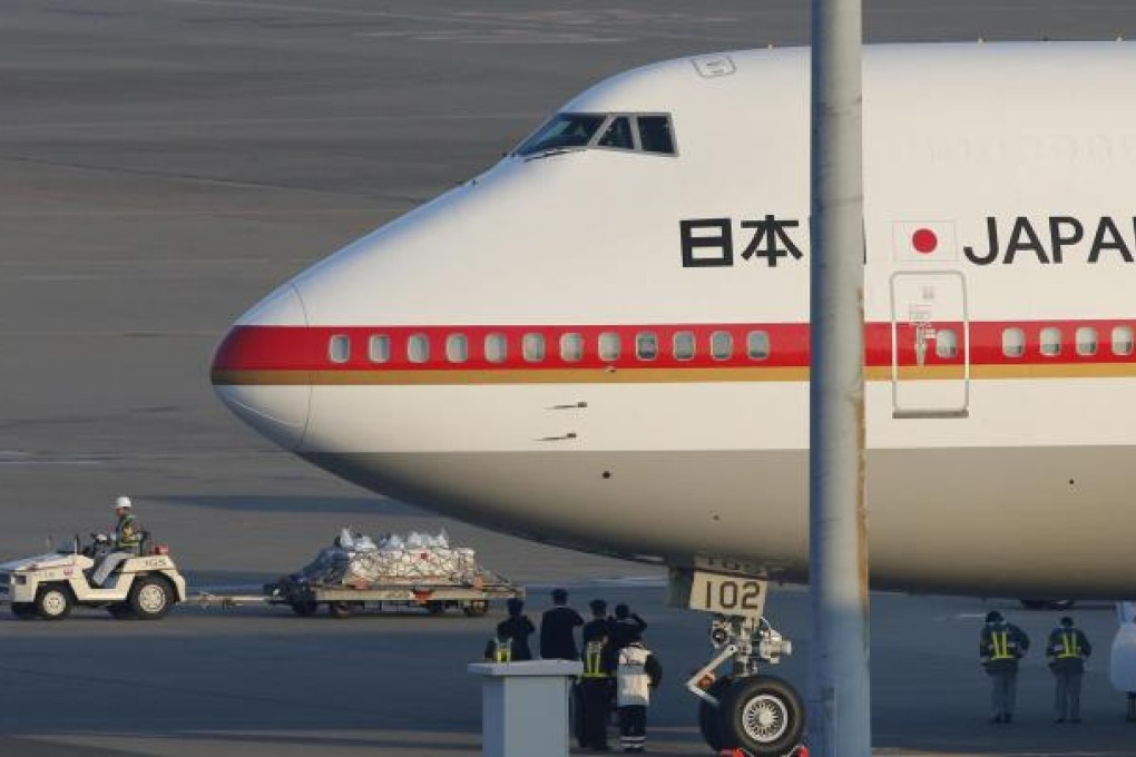 Three of the Algeria siege victims’ coffins are saluted by air crew as they are carried away from the Japanese government plane. Photo: AP
