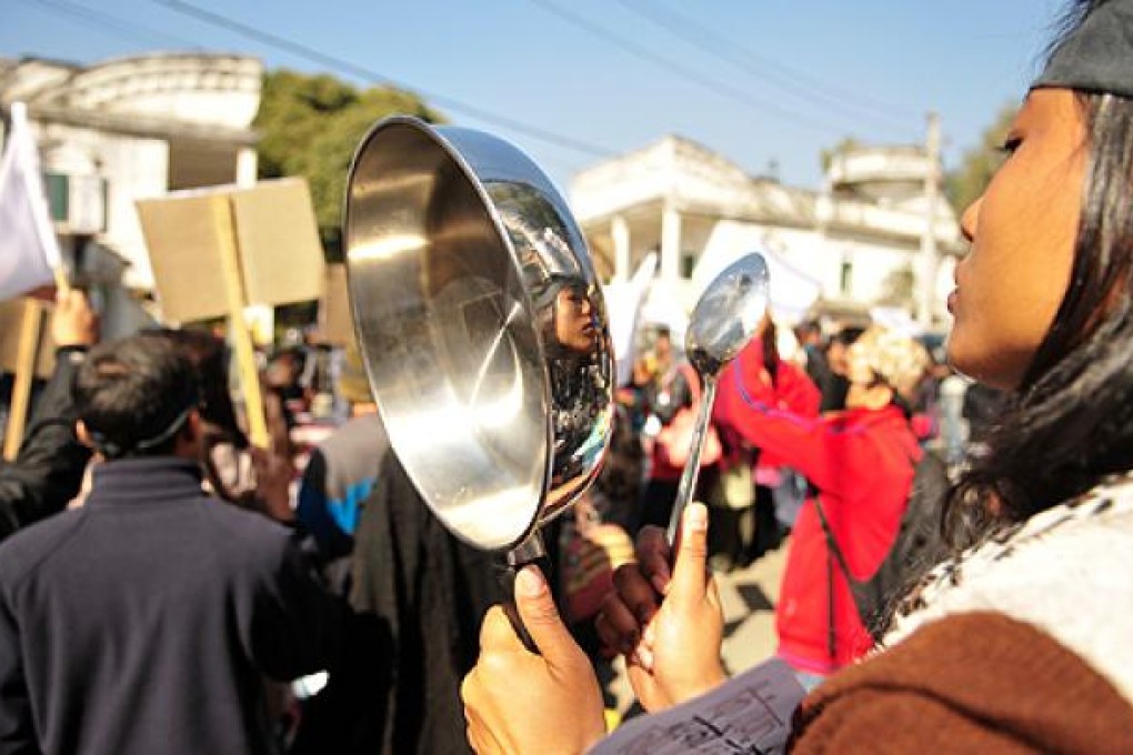 A Nepalese woman knocks a frying pan as she participates in a demonstration against violence on women in Kathmandu, on Tuesday. Photo: Xinhua