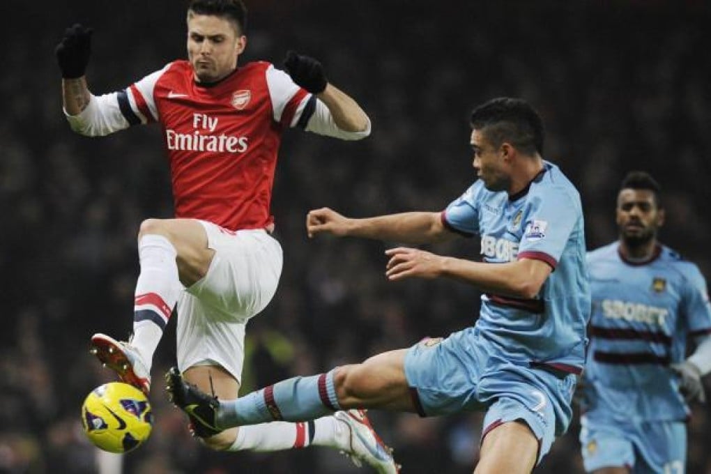 Arsenal's Olivier Giroud competes for control of the ball with West Ham United's Winston Reid at the Emirates Stadium. Photo: EPA
