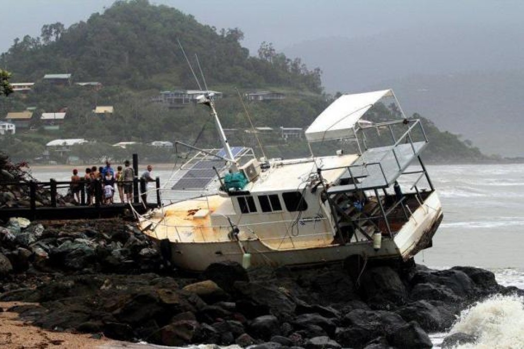 A boat washed up onto rocks in Queensland. Photo: Reuters