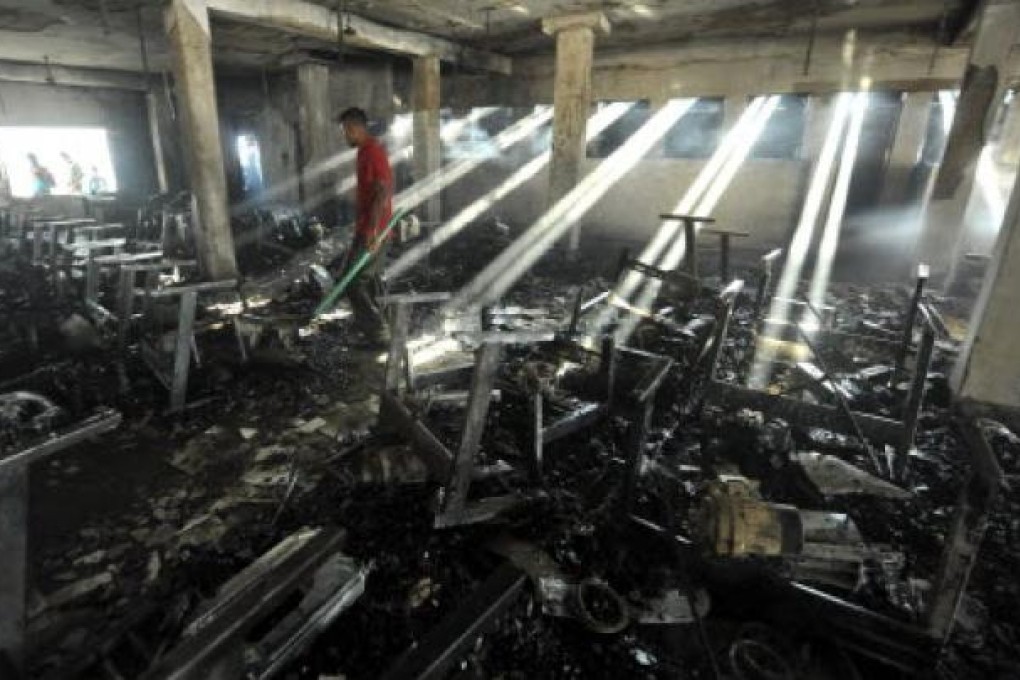 People look for things to salvage after a fire at the Smart Fashions garment factory in Dhaka on Saturday. Photo: Reuters