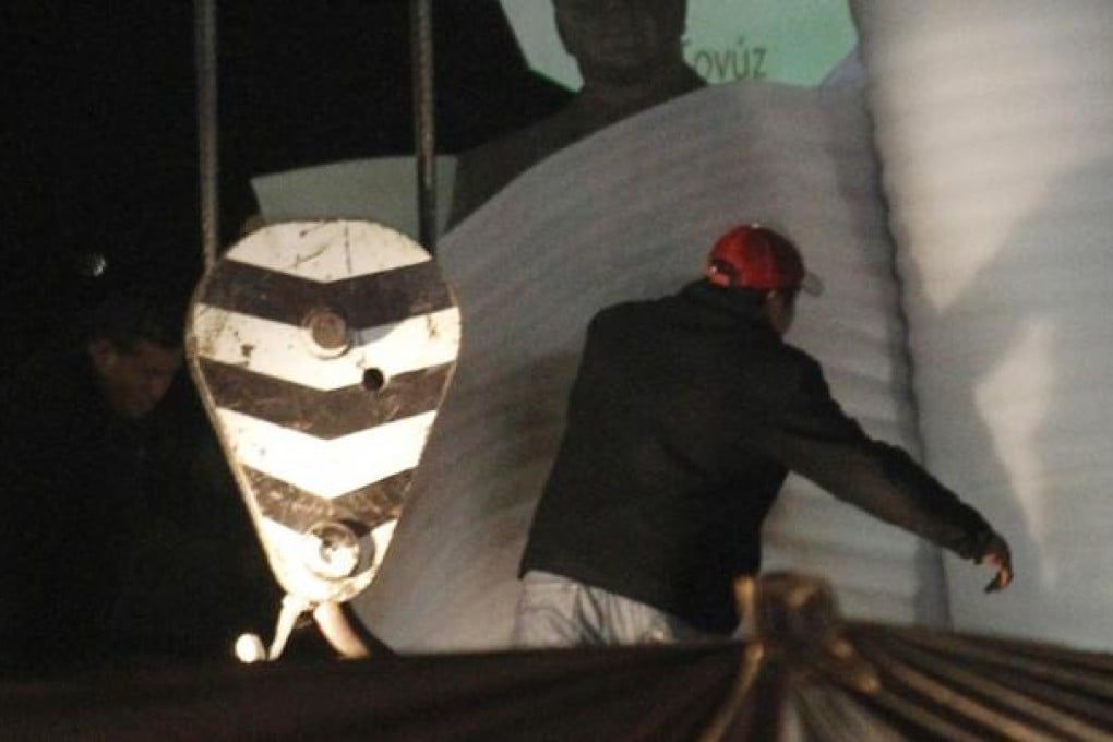 The bronze statue of Heydar Aliyev is bundled up and removed from its perch on Mexico City's Paseo de La Reforma. Photo: Reuters