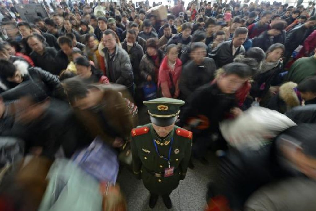 A paramilitary policeman stands firm as crowds pack Yinchuan railway station, Ningxia Hui. Photo: Xinhua