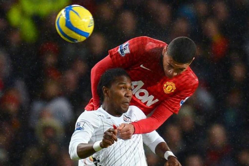 United defender Chris Smalling rises above Fulham's forward Hugo Rodallega to get the ball. Photo: AFP