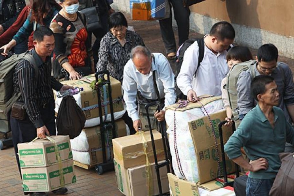 Parallel traders wait outside the Sheung Shui MTR station. Photo: Sam Tsang