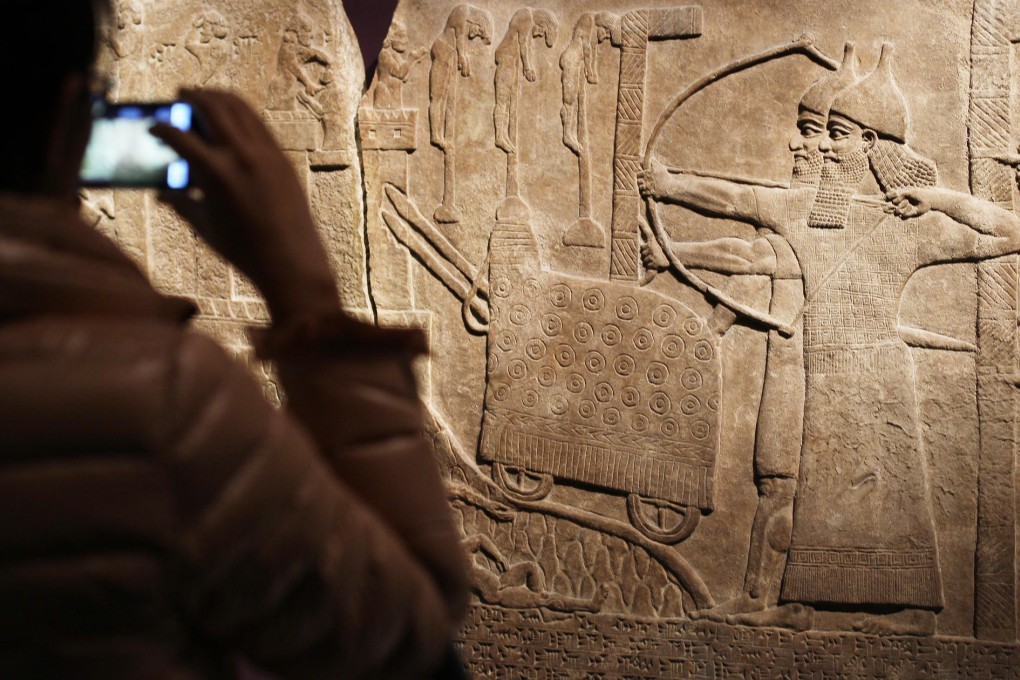 A visitor photographs the wall relief “Attack on an enemy town” of an Assyrian assault on a town in Turkey in 738-737BC. Photo: Sam Tsang