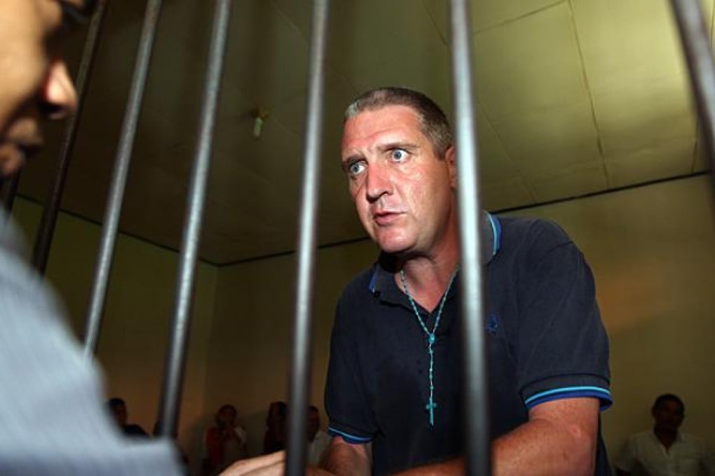 Briton Julian Anthony Ponder talks to his lawyer ahead of his verdict trial in Denpasar. Photo: AP