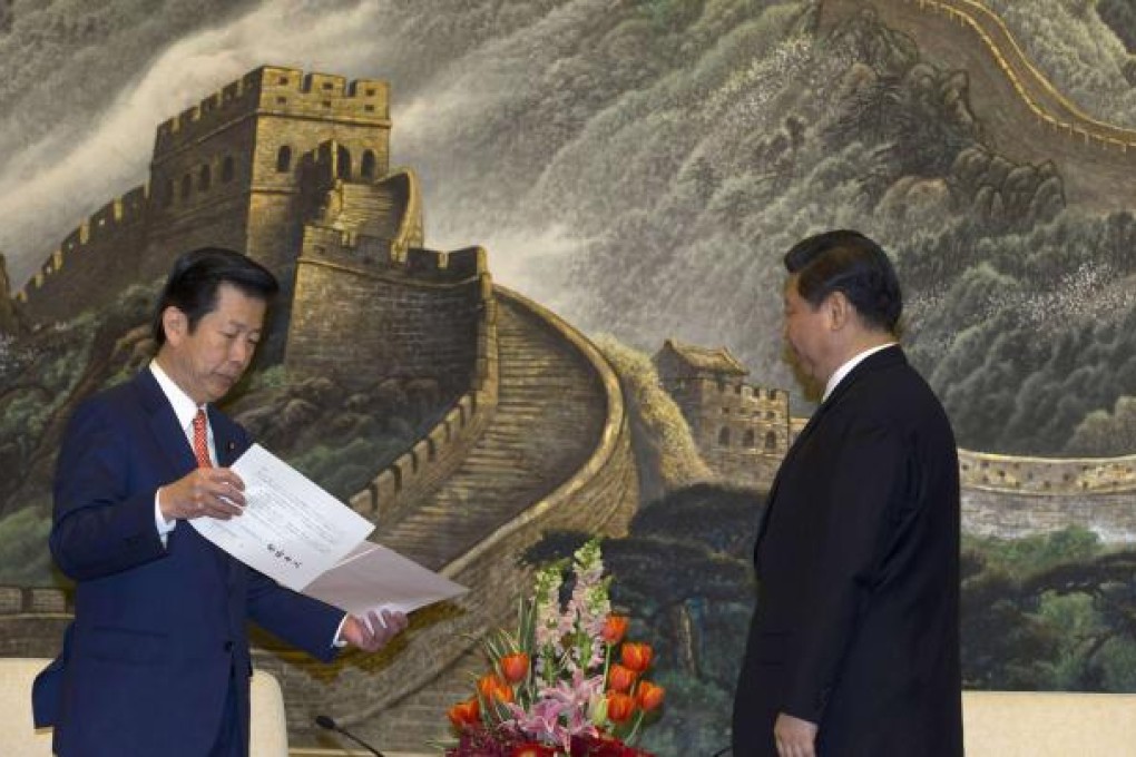 Yamaguchi, leader of Japan's New Komeito party, prepares to deliver a personal letter from Japan's Prime Minister Abe to China's president-in-waiting Xi during a meeting at the Great Hall of the People in Beijing. Photo: Reuters