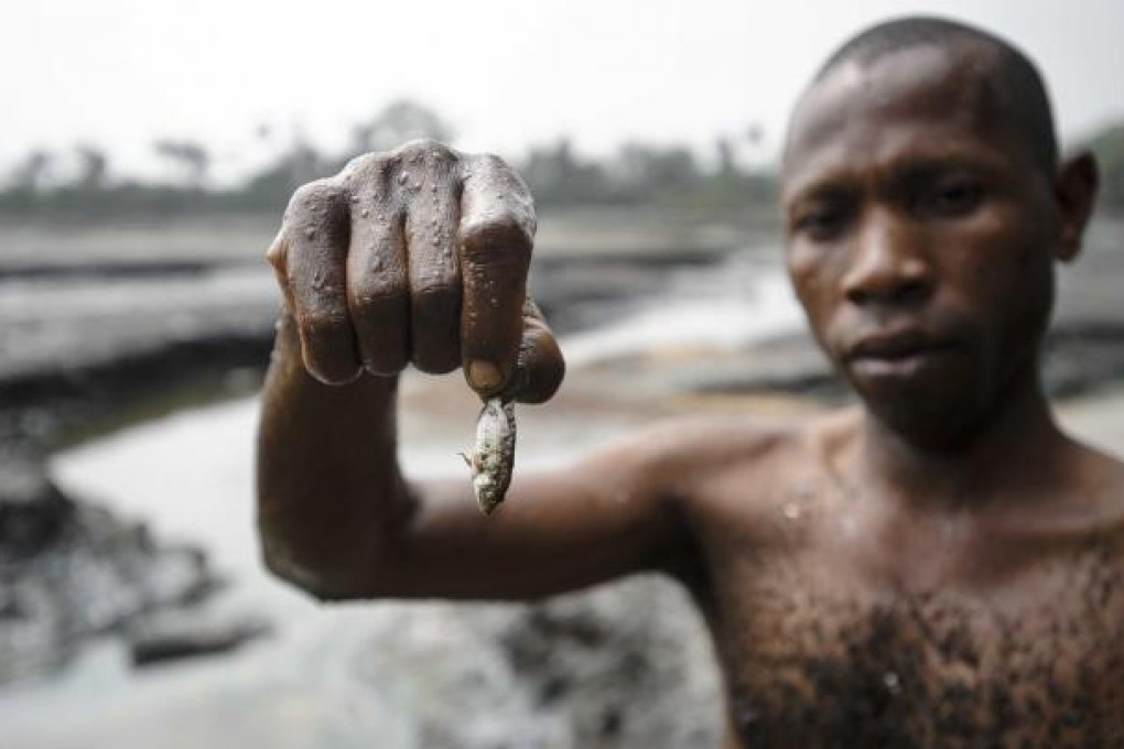 A fisherman shows his meagre catch from a Nigerian creek. Photo: EPA