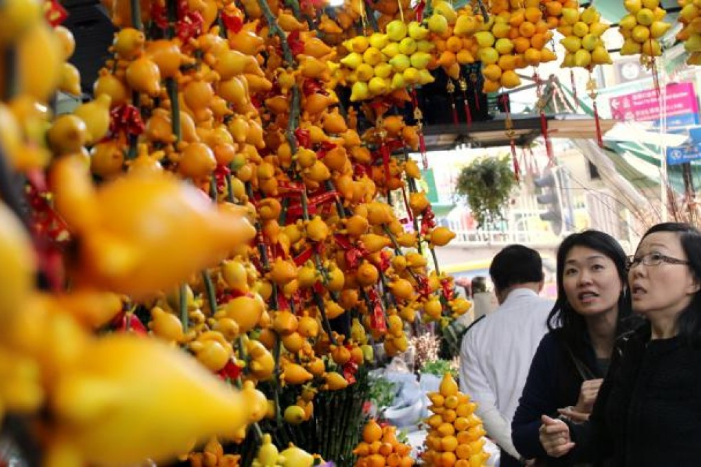 Shoppers inspect decorative plants on offer at a market in Mong Kok ahead of the Lunar New Year. Sellers say they expect to fetch good prices for plants sold in the run-up to the holiday - which starts on February 10 - with most costing 10 per cent more than last year. Photo: Felix Wong