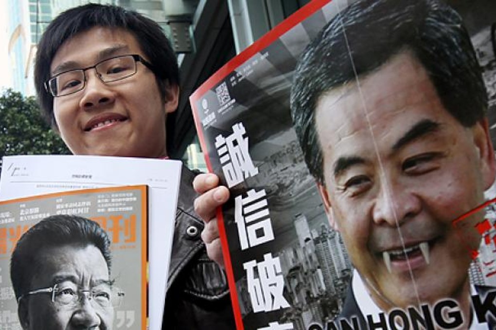 Raphael Wong Ho-ming with photos of Lew Mon-hung, left, and Leung Chun-ying, right, before entering the ICAC headquarters in North Point on Wednesday. Photo: David Wong