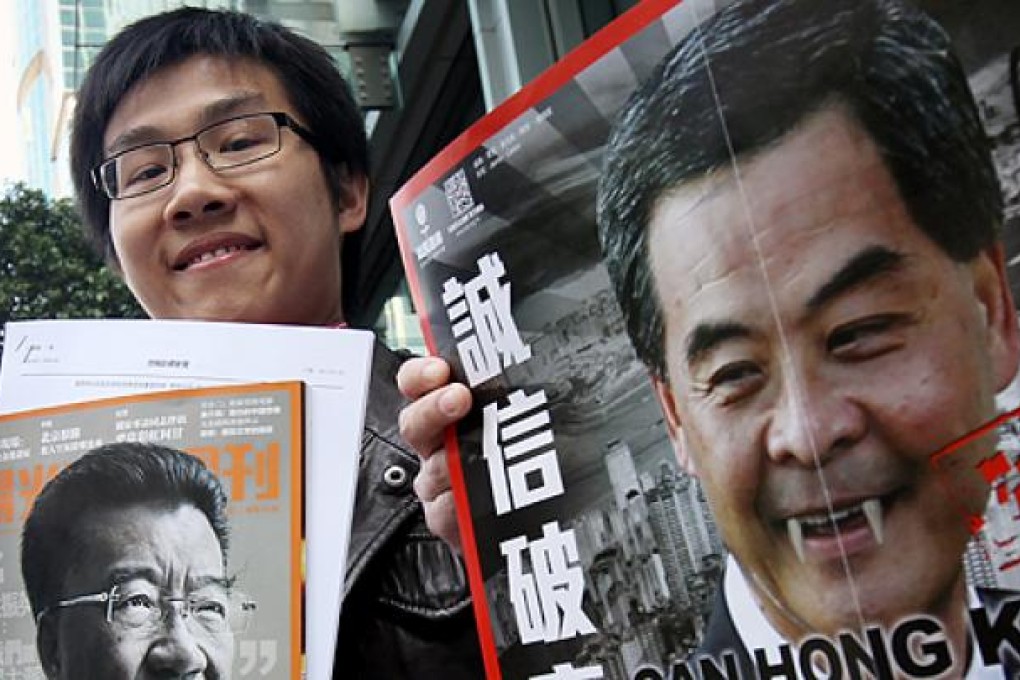 Raphael Wong Ho-ming with photos of Lew Mon-hung, left, and Leung Chun-ying, right, before entering the ICAC headquarters in North Point on Wednesday.  Photo: David Wong