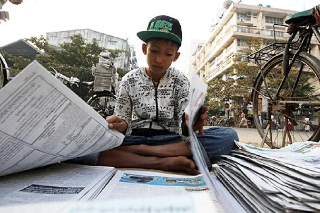 A boy sells newspapers in Yangon, Myanmar. Photo: Reuters