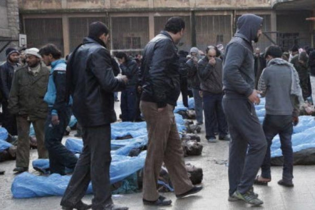 Residents attempt to identify bodies found along a river at a school used as a field hospital in Aleppo's Bustan al-Qasr on Tuesday. Photo: Reuters