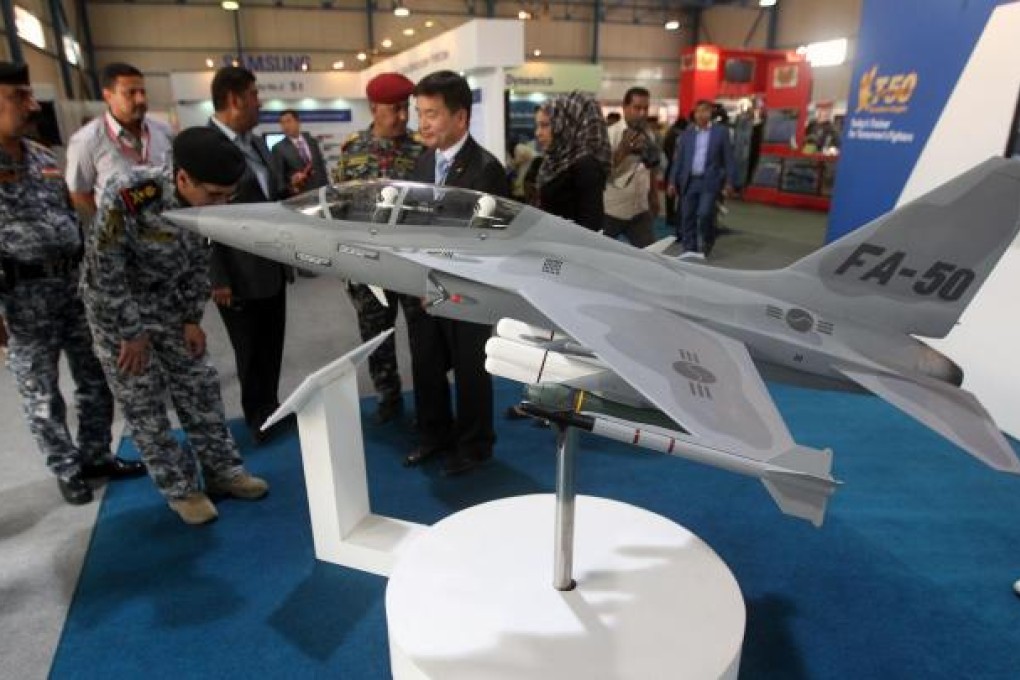 Military officials looking at a model of a FA-50 fighter jet. Manila will soon finalise a US$443 million deal to buy 12 of the jets. Photo: AFP