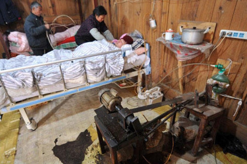 Fu Xuepeng lies in bed as his father pumps air. Photo: SCMP