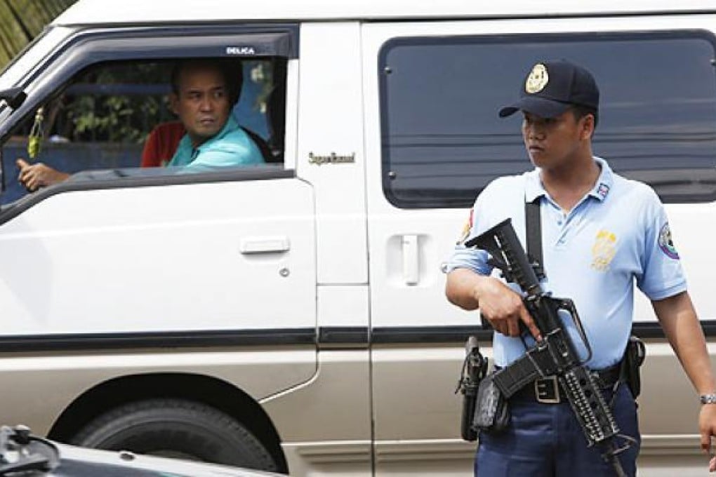 A policeman watches passing vehicles at a police checkpoint. Checkpoints have been set up to enforce a national gun ban aimed at curbing violence ahead of mid-term elections in May. Photo: EPA