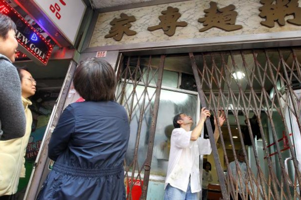 Customers queue outside Lei Yuen, a 40-year-old noodle and congee shop in Causeway Bay which will be closed because of soaring rents. Photo: SCMP