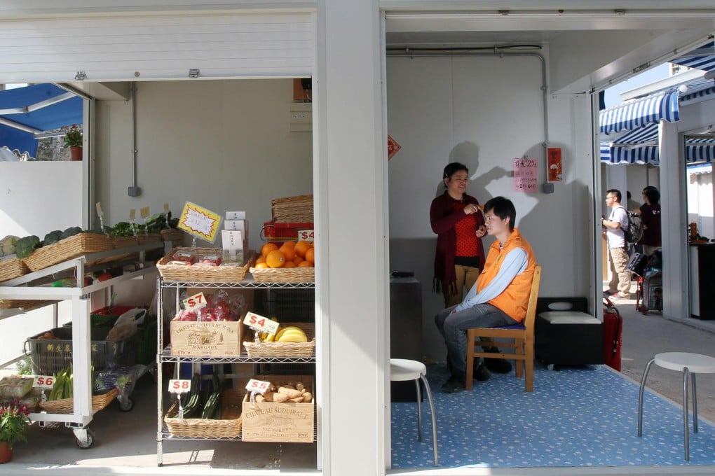 A woman operates her barber shop next to a vegetable stall at the newly opened Tin Sau Market in Tin Shui Wai yesterday. Photo: K. Y. Cheng