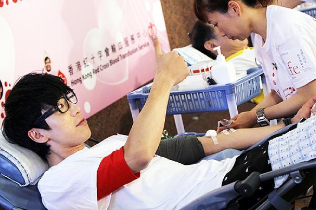 Luk Wing-kuen from hip-hop duo FAMA gives blood on World Blood Donor Day. Photo: David Wong