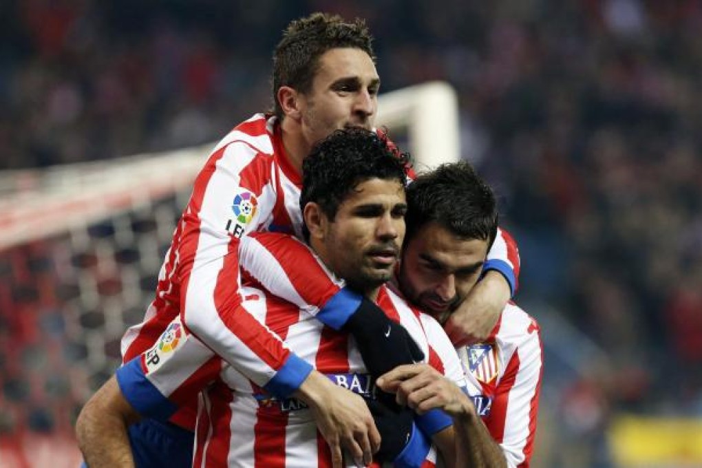 Diego Costa is congratulated after scoring a penalty in a 2-1 win for Atletico Madrid over Sevilla in their King's Cup semi-final. Photo: EPA