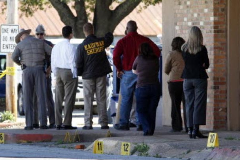 Kaufman law enforcement officers and others gather around the area where an assistant district attorney was killed on Thursday. Photo: AP