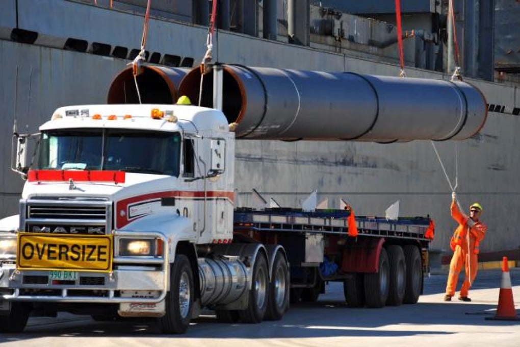 Gas pipes for a liquefied natural gas (LNG) pipeline are unloaded at a port in Brisbane. Photo: Bloomberg