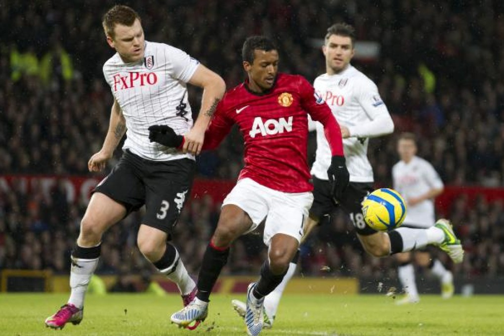 Manchester United's Nani (centre) fights for the ball against Fulham's John Arne Riise (left), as Aaron Hughes looks on during their English FA Cup fourth round soccer match at Old Trafford Stadium. Photo: AP
