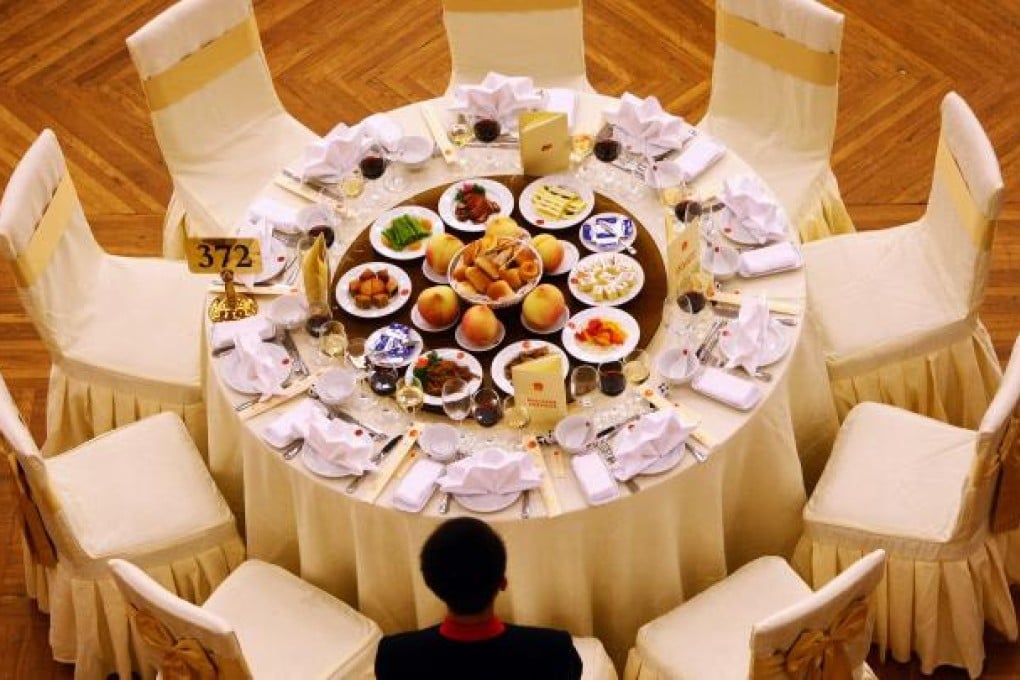 A waiter stands next to a table prepared for an official banquet on the eve of the 60th anniversary of the founding of the People's Republic of China. Photo: AFP