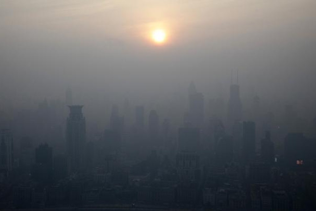 The sun sets behind commercial buildings shrouded in haze in Shanghai, China. Photo: Bloomberg