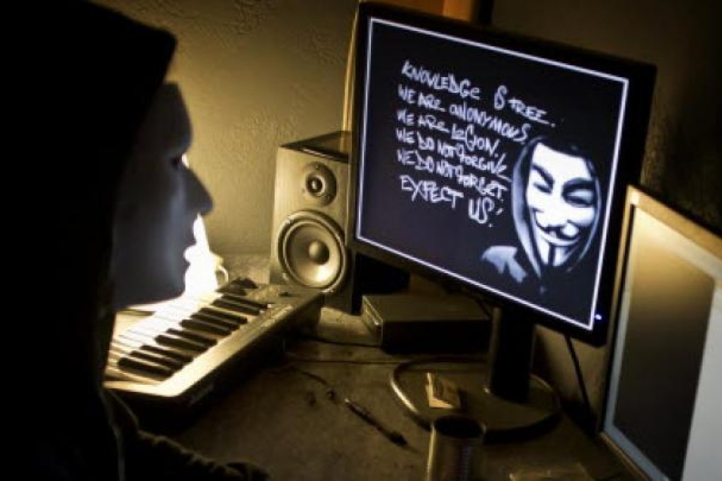 A masked hacker hacks the French presidential Elysee Palace website. Photo: AFP