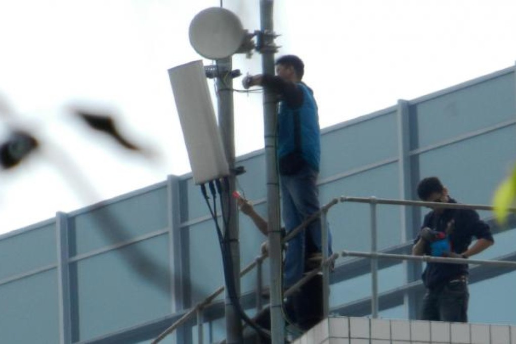 Workmen remove antennae from UST rooftops last week, after a controversy over the number of masts on the campus. Photo: Red Door News