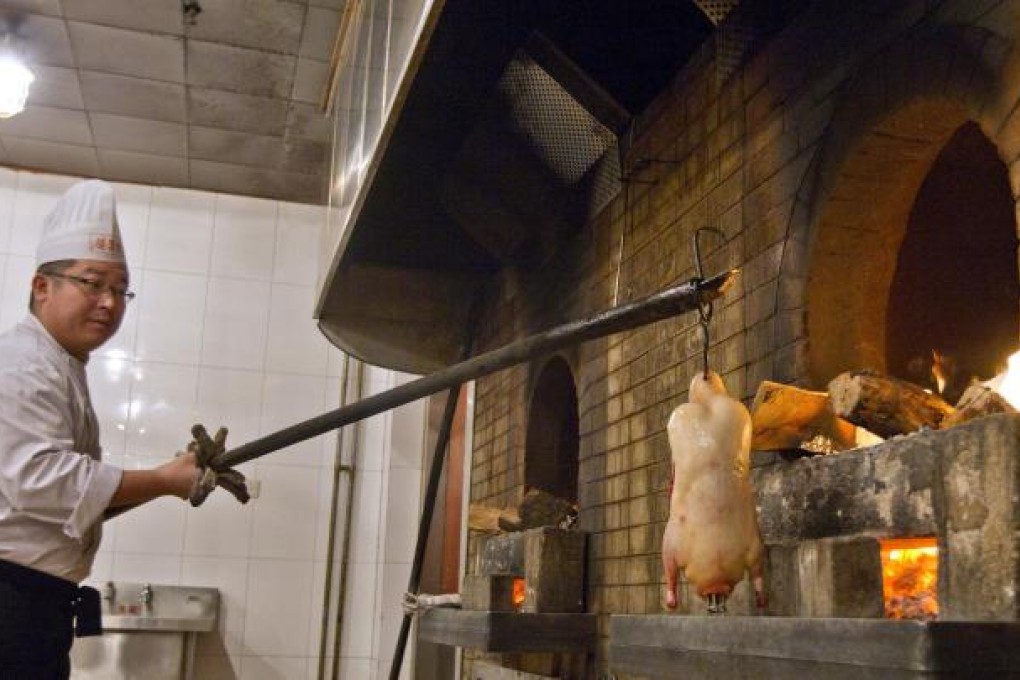 A duck goes into the oven at one of Quanjude's restaurants in Beijing, where the business began in 1864. Photo: Simon Song
