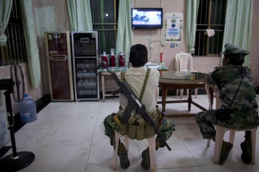 Kachin Independent Army (KIA) soldiers watch a TV program at a restaurant in the town of Laiza, in northern Myanmar's Kachin-controlled region. Photo: AP