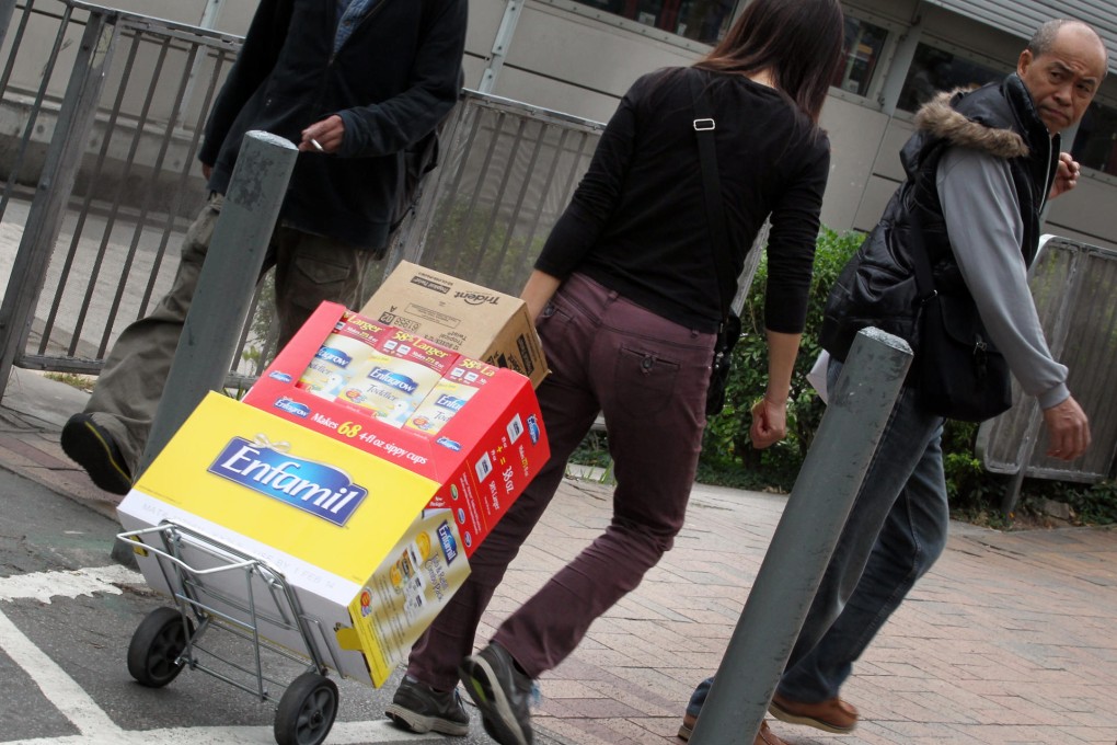 A woman carries milk powder to the MTR. Photo: Nora Tam