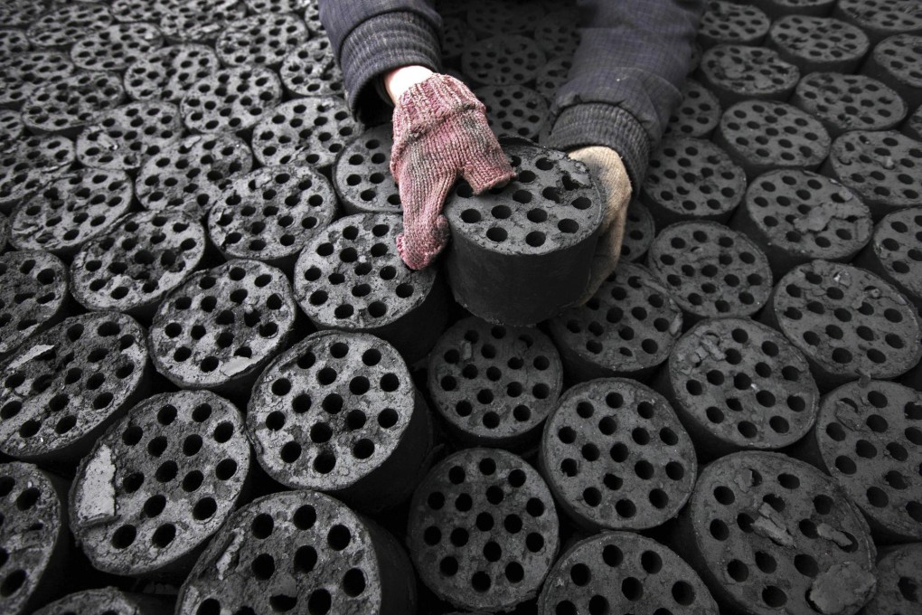 A worker collects coal briquettes in Anhui province. Photo: AFP