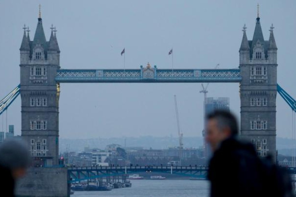 Commuters walk across London Bridge, as Tower Bridge is seen in the background in the City of London on January 25, 2013. Photo: AFP