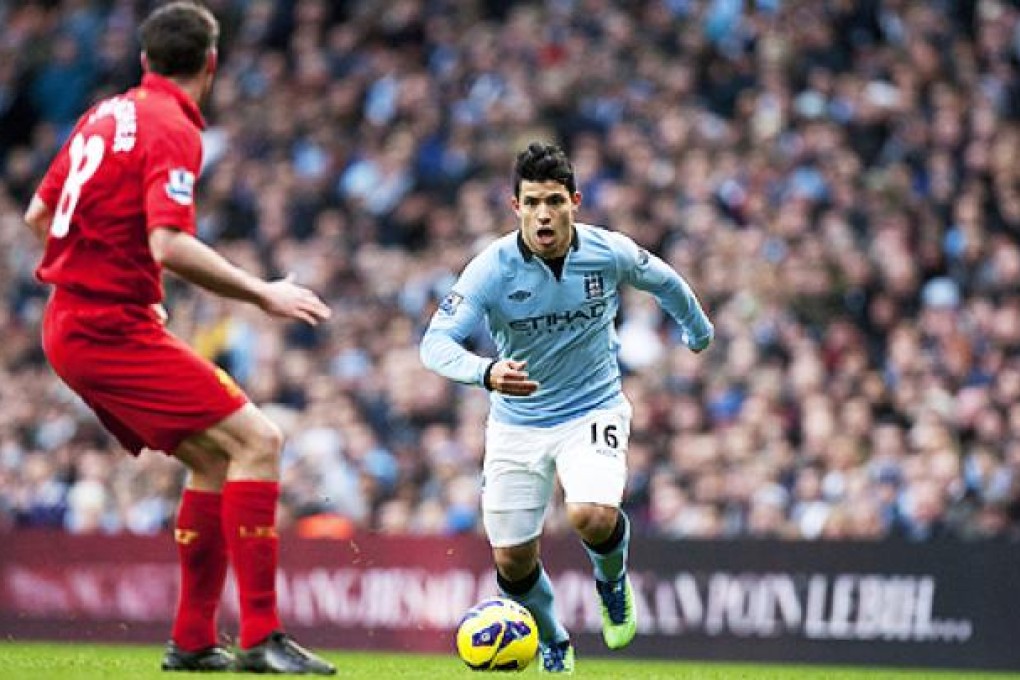 Manchester City's Sergio Aguero takes the ball down field against Liverpool's Jamie Carragher. Photo: AP