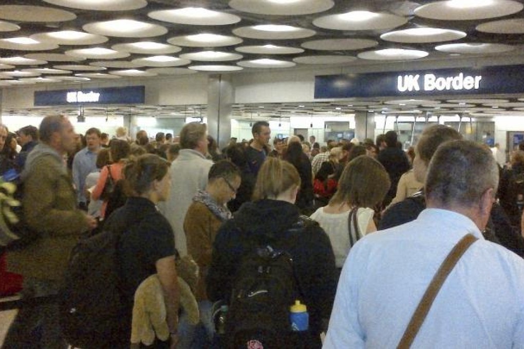 Travellers queue to be processed by UK Border Agency immigration control officers at Heathrow airport in London. Photo: Reuters