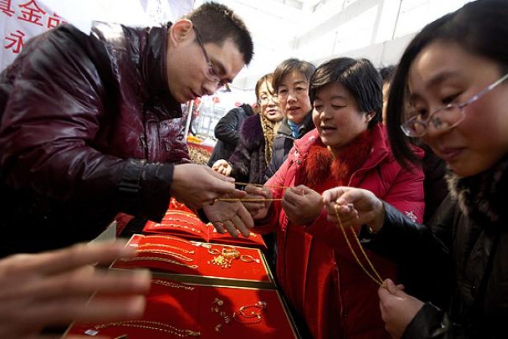 Shoppers buy gold jewellery at a Spring Festival fair in Jinan city, Shandong province. Photo: EPA