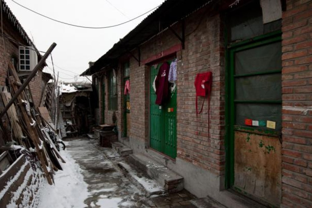 Clothes hang from the entrance of a single-story brick house, known as a "black jail" in Beijing. Photo: AP