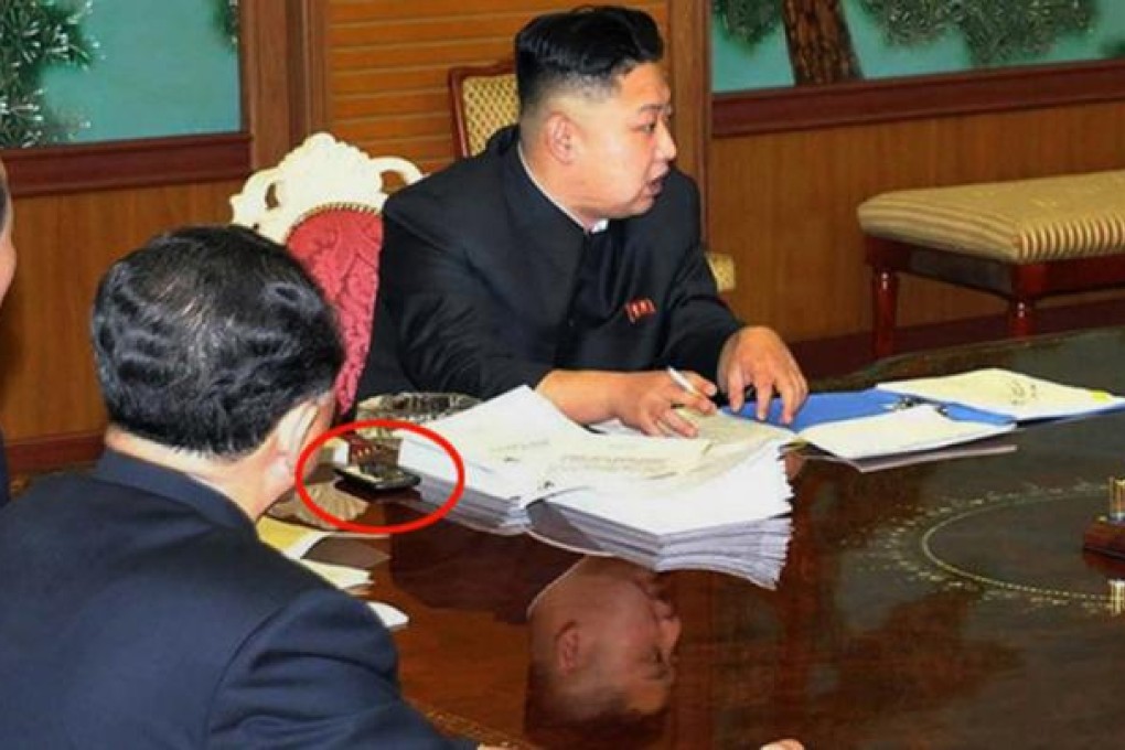 A black smartphone lies beside documents on the table in front of Kim Jong-un. It’s believed to be an HTC. Photo: AFP