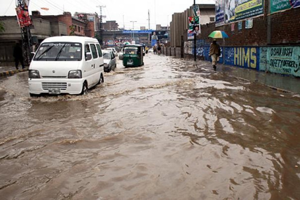 Vehicles drive along a flooded street in northwest Pakistan's Peshawar on Wednesday. Photo: Xinhua