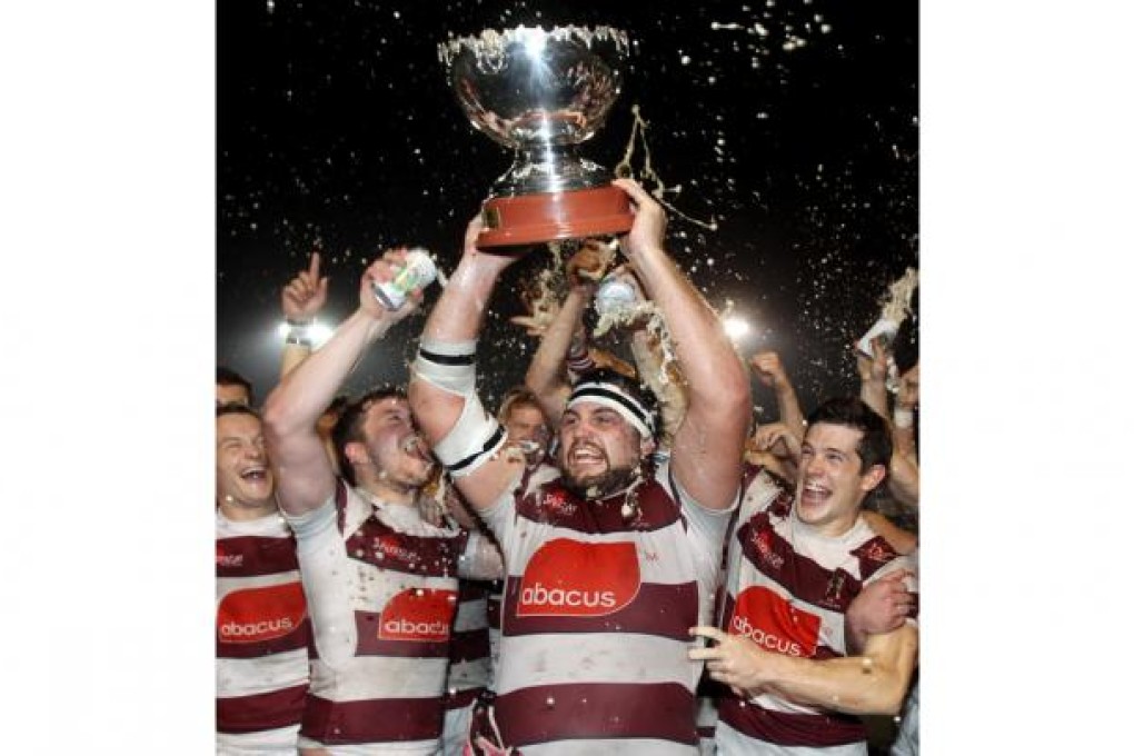 Captain Matt Stockdale of Kowloon lifts the trophy aloft after their win over Valley at King's Park last night. Photo: Edward Wong