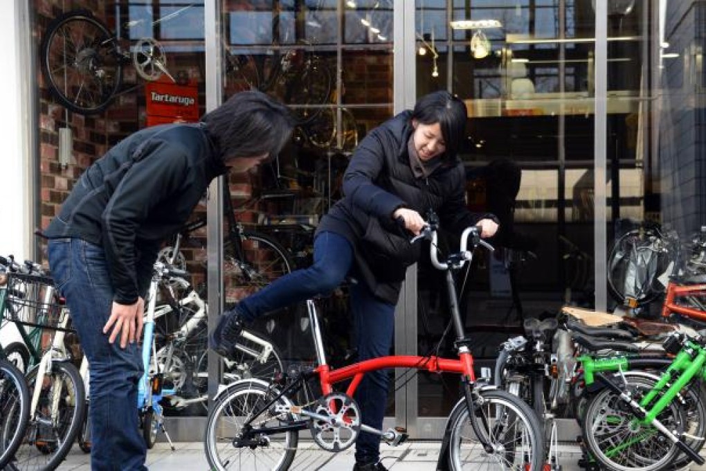 A Japanese customer in Yokohama tries out a folding bike made by Brompton. The UK cycle maker said its business is doubling every four to five years. Photo: AFP