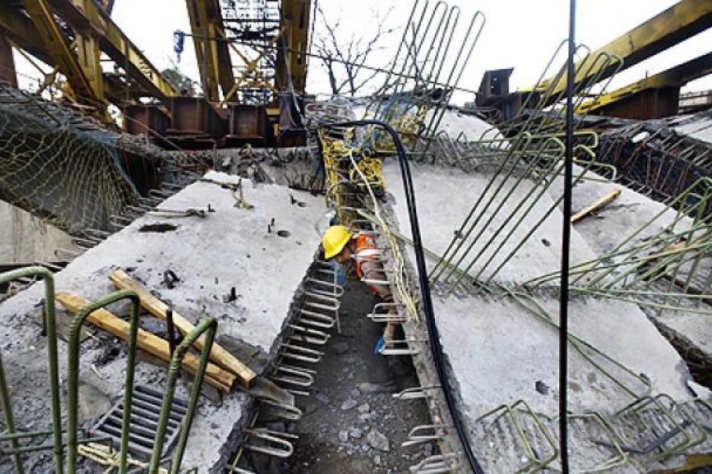 An rescue worker looks for survivors under the rubble of a bridge that collapsed in Mumbai on Thursday. Photo: AP