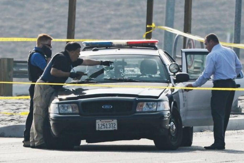 Police investigators inspect the bullet-riddled LAPD squad car in which a police officer was shot on Thursday in Corona, California. Photo: AFP